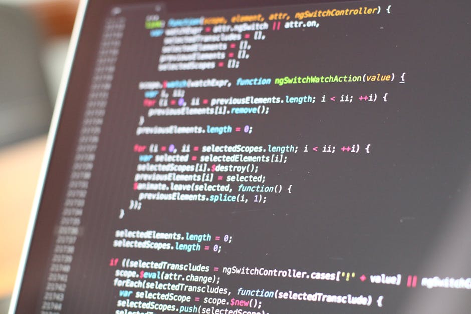 A close-up view of an open laptop placed on a wooden table in a garden setting, displaying lines of code on its screen. In the background, there are blurred elements of a cozy outdoor workspace with w